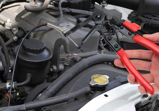 A person fixing the car's accelerator cable with the orion motor tech hose clamp pliers.