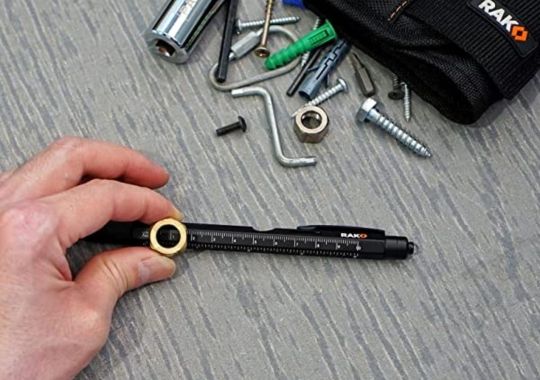 A person measuring the diameter of a nut with rak mult-tool pen set.
